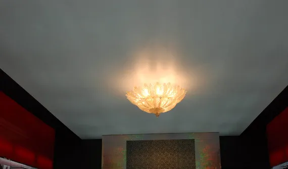 Candelabru clasic aprins, montat pe un tavan întunecat
